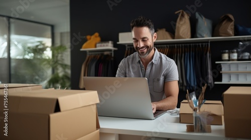 A small business owner works on their laptop preparing aesthetic packaging for products like boxes for customers. It has an e-commerce concept, SME business online concept.