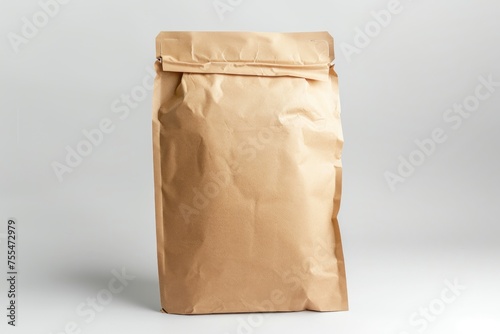 A brown paper bag is sitting on a white surface. The bag is open and has a white label on it