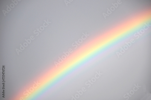 Bunter Regenbogen am Himmel: Ein Wetterereignis mit kreisbogenförmigen Lichtspiel und optisches Phänomen bei Regen mit Sonne gleichzeitig