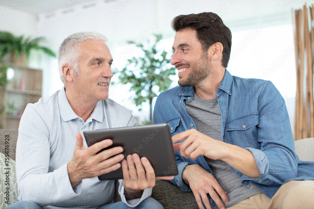 senior father and young son with tablet