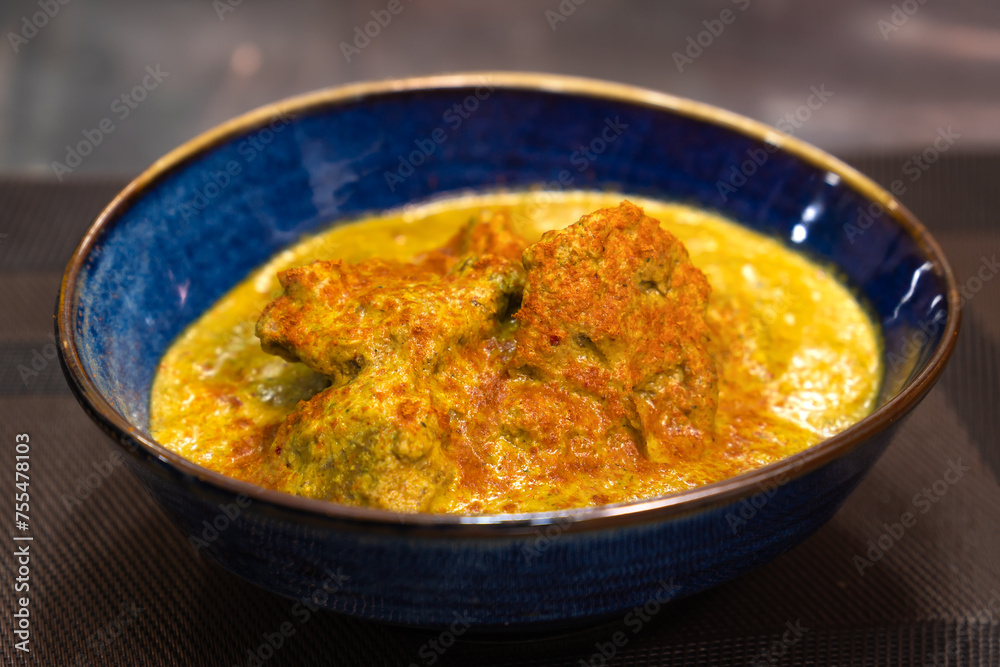 Satsivi is a traditional Georgian dish of chicken in walnut sauce in a blue plate on the table Satsivi is a traditional Georgian dish of chicken in walnut sauce in a blue plate on the table