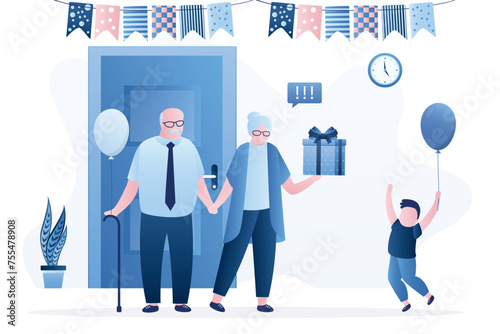 Grandparents gives his grandson gift. Happy boy jumping. Unpacking the gift box. Celebrating birthday or christmas. Family holiday event.