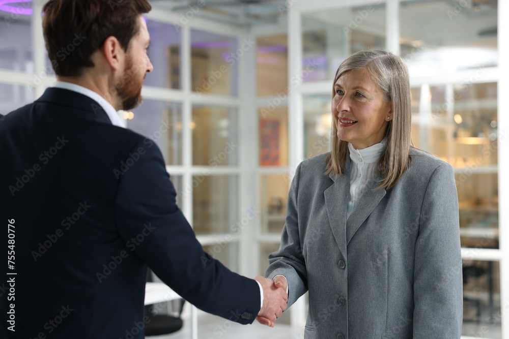 Lawyer shaking hands with client in office