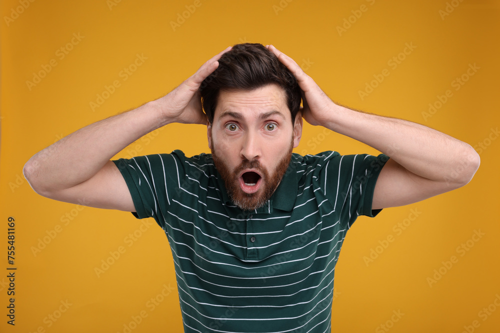 Portrait of surprised man on yellow background
