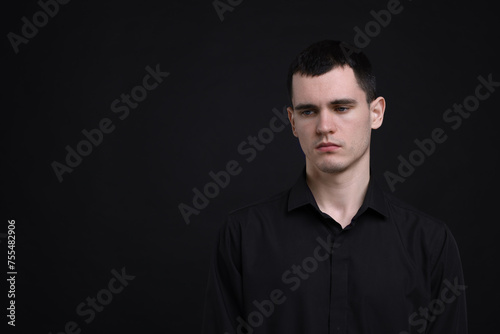 Portrait of sad man on black background, space for text