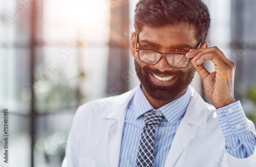 Portrait of a smiling male doctor standing in a hospital corridor