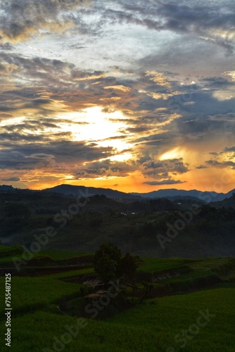 sunset over rice fields with mountains in the background in Ruteng, Manggarai, Indonesia. photo