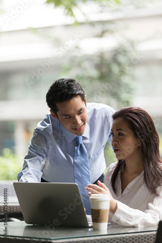 Asian business people working together on a laptop