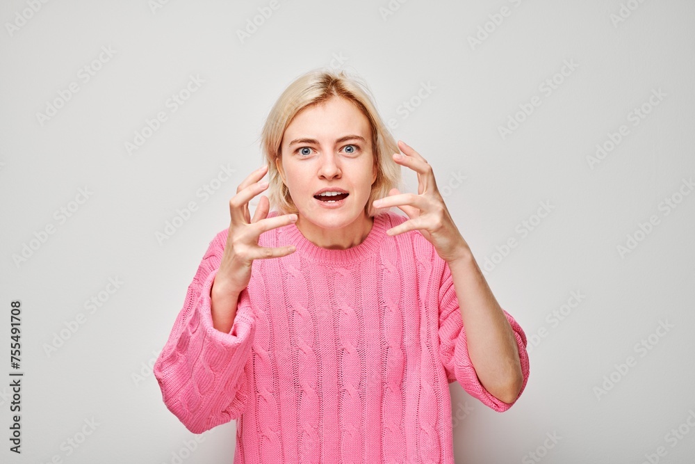 Surprised young woman in pink sweater gesturing with hands, isolated on white background. Surprised young woman in pink sweater gesturing with hands, isolated on white background.