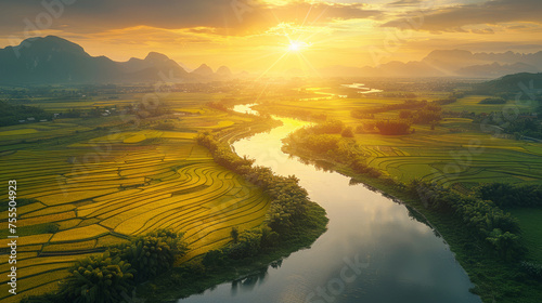 Golden sunset over tranquil river flowing through lush rice fields