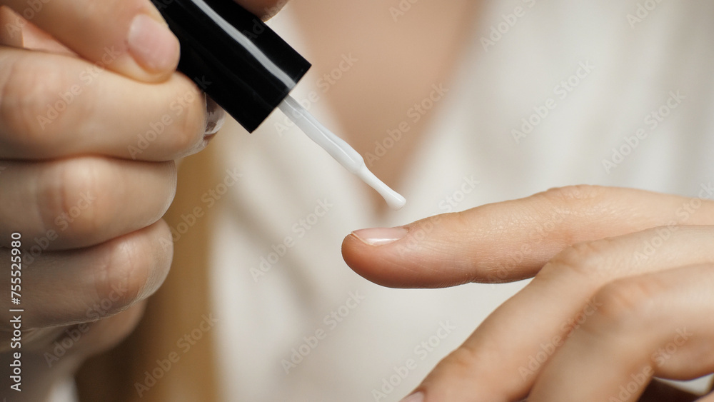Close-up of applying nail polish on a nail. Nail brush. Manicure. Beauty care Close-up of applying nail polish on a nail. Nail brush. Manicure. Beauty care