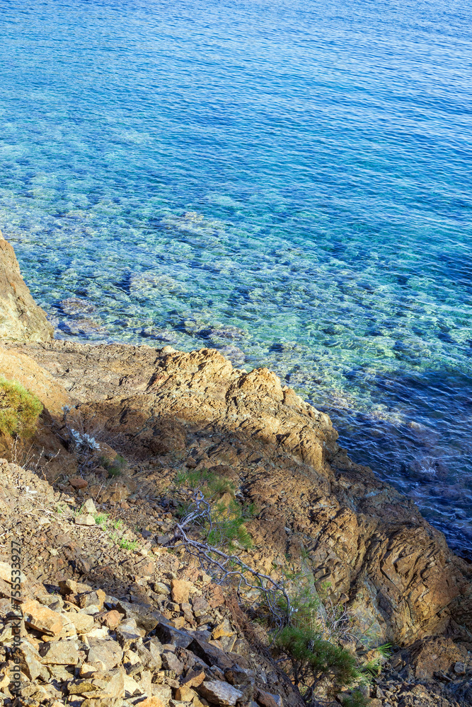 Beach, crystal clear water in Mediterranean sea near to cliff. Cirali, Antalya Province in Turkey.