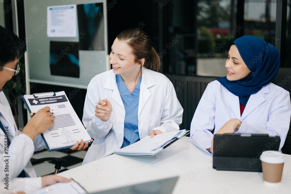 Fototapeta premium Medical, meeting and laptop for team in discussion, brainstorming and planning. Doctor, nurse on desk show diversity in collaboration, teamwork or workshop in hospital .
