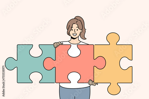 Successful woman unraveling puzzle and solving complex task while developing own startup. Smart girl with smile demonstrates problem solving skills and ability to create team for business.