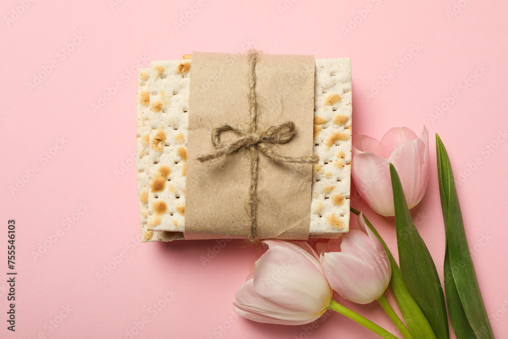 Matzo and flowers on pink background, top view Matzo and flowers on pink background, top view