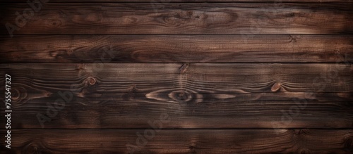 A wooden wall with a dark brown color serves as a textured background. The woods grain is visible and adds a rustic touch to the space.