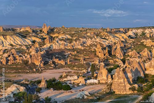Cappadocia's fairy chimneys and carved dwellings at sunset, highlighting a unique, rugged landscape in golden light. Goreme valley and its unique geological forms. Nevsehir, Turkey (Turkiye)