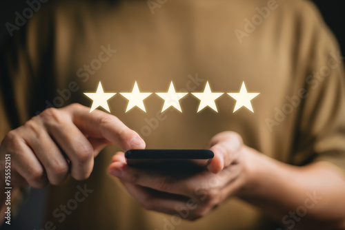 Customer service experience and business satisfaction survey, close up Woman hand using smart phone and give five star symbol to increase rating of product and service concept.