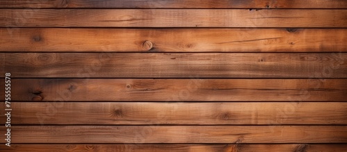 A close-up view of a wooden wall made of brown planks. The planks are arranged horizontally, creating a textured and rustic appearance.