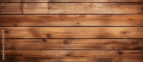 A close-up view of a wooden wall with a brown stain covering its surface. The textured planks form a rustic background with a weathered appearance.