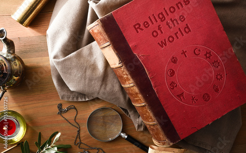 Old book of religions with ancient objects on wooden table
