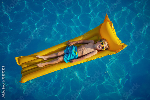 Little boy lounging on a bright yellow inflatable mattress