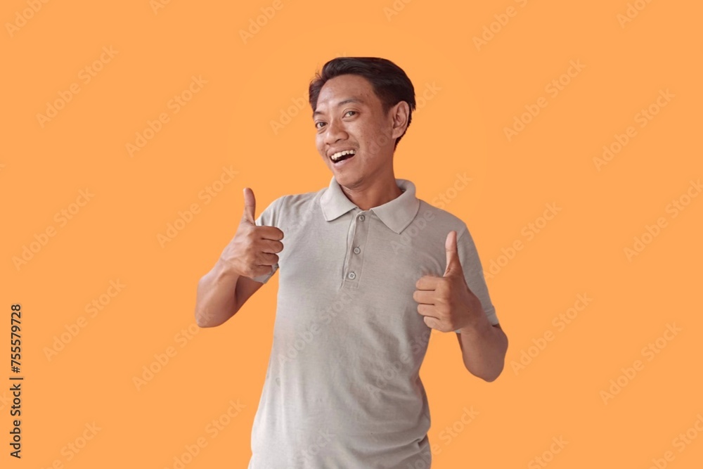 Handsome Asian man standing over orange background pointing to the back behind with hand and thumbs up, smiling confident Handsome Asian man standing over orange background pointing to the back behind with hand and thumbs up, smiling confident