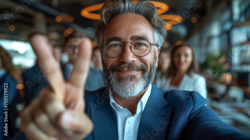 happy mature businessman making victory hand sign