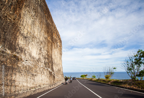 Road and limestone cliffs leading to Melasti Beach in Bali, Indonesia. Melasti Beach is one of the favorite tourist locations on the island of Bali. photo