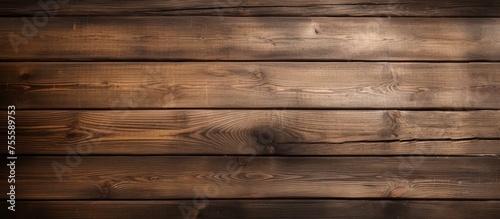 A wooden wall is illuminated by a bright light source, casting a warm glow on the textured surface. The light creates a play of shadows and highlights, enhancing the natural grain and patterns of the