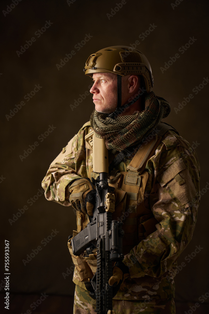 portrait of an airsoft soldier in camouflage clothing with a rifle with a telescopic sight