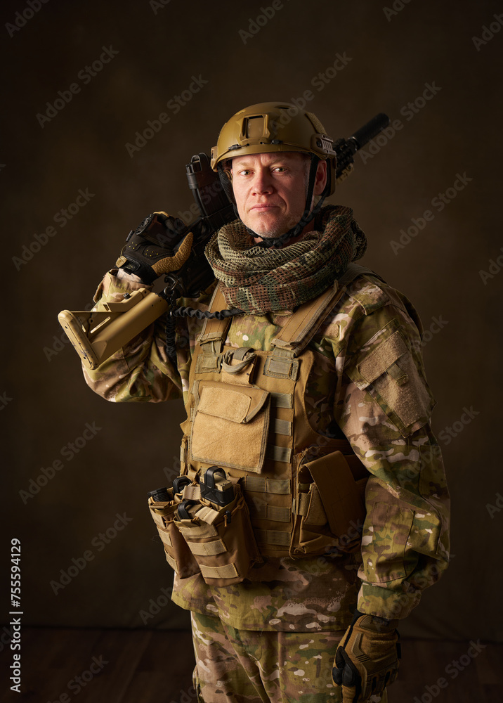 portrait of an airsoft soldier with camouflage clothing and a rifle with a telescopic sight