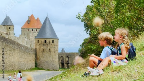 Children on their family trip have break near Carcassonne castle