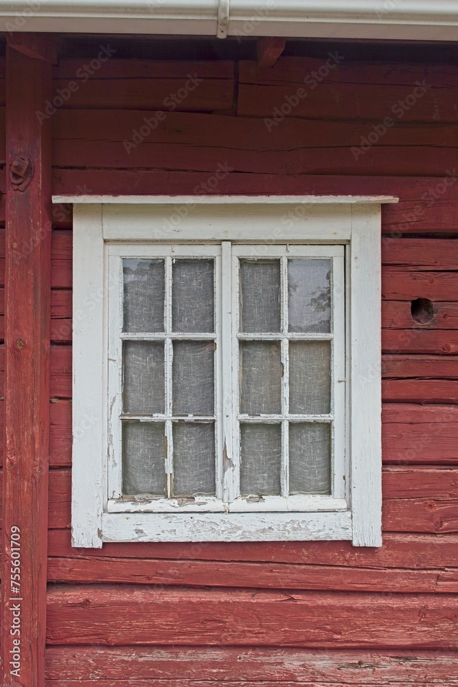 White framed window on a old red painted wooden building. White framed window on a old red painted wooden building.