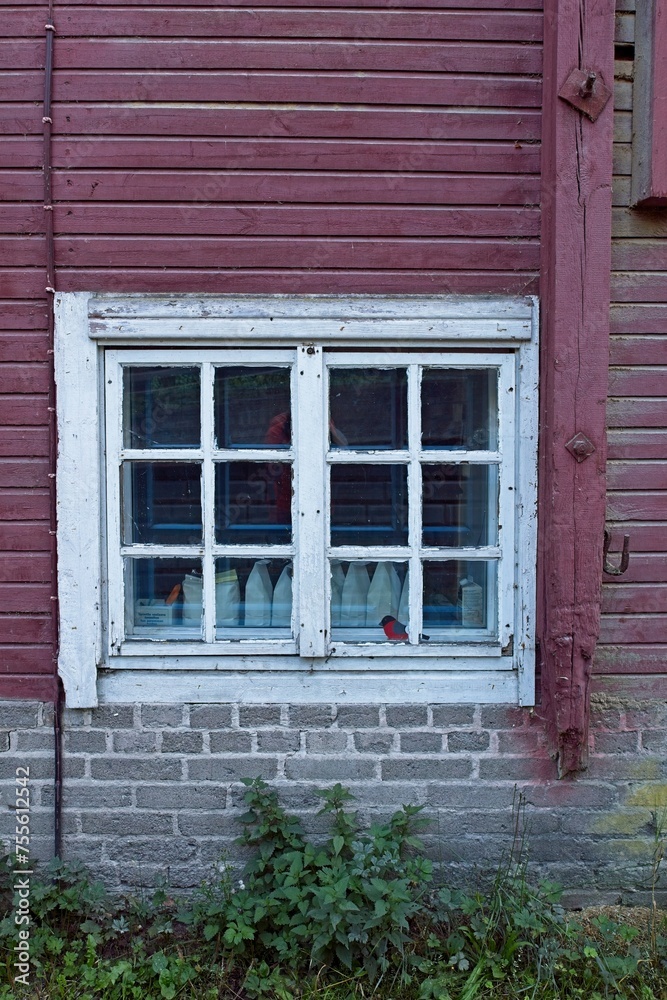 Wooden red wall with white painted frame window. Wooden red wall with white painted frame window.