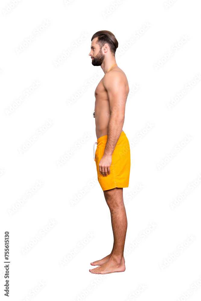 Side view snap full size fullbody portrait of attractive strong lifeguard with stubble, modern hairstyle in yellow shorts isolated on grey background