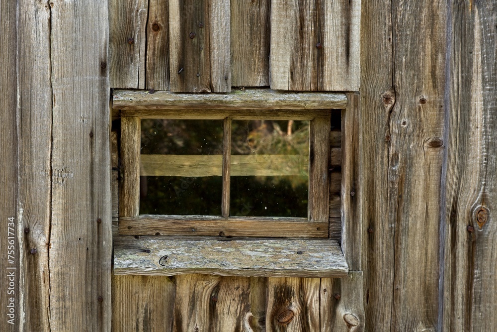 Small framed window on weathered wooden building.