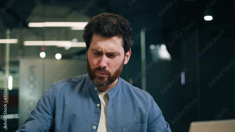 Unhealthy bearded man working by computer while getting interrupted by sharp abdominal pain and rubbing belly with hands. Sick manager having digestion problem during busy day in modern office. Unhealthy bearded man working by computer while getting interrupted by sharp abdominal pain and rubbing belly with hands. Sick manager having digestion problem during busy day in modern office.
