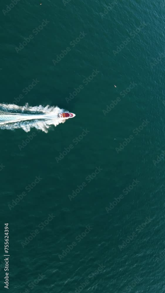 Aerial drone shot over the boat. Foam trail with waves. High speed white yacht from above. Vertical video. Aerial drone shot over the boat. Foam trail with waves. High speed white yacht from above. Vertical video.