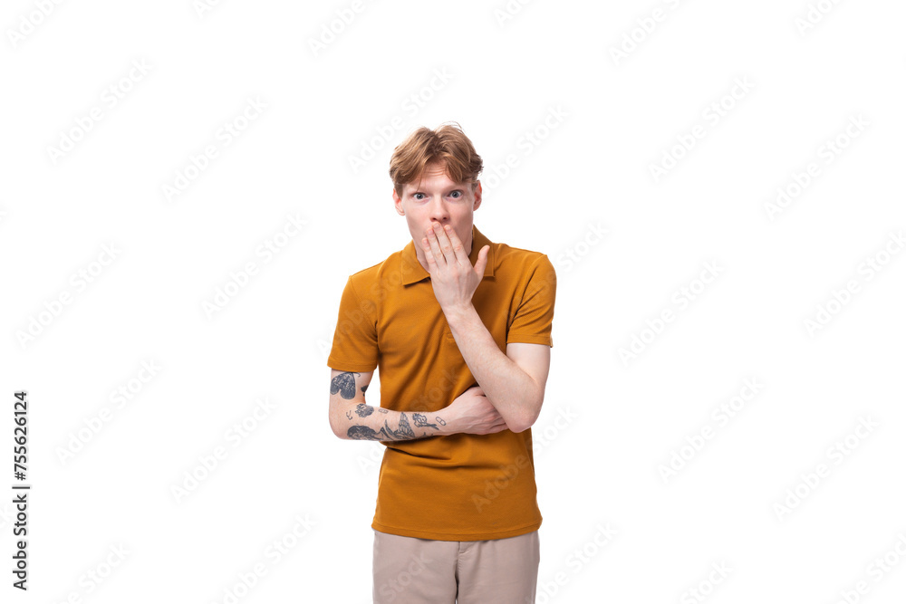 young smart guy with red hair stands thoughtfully on a white background with copy space young smart guy with red hair stands thoughtfully on a white background with copy space