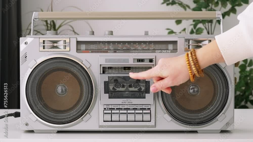 Woman hand puts cassette into deck recorder playing music close up. Analog tape recorder plays  audio cassette spins plays music close up slide top front. Retro tape reels rotate 