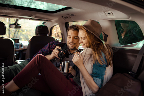 Happy young couple in a car on road trip photo