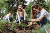 Young people volunteers outdoors planting trees digging ground talking cheerful