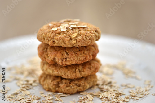 Oatmeal cookies with oat flakes on a white plate. Healthy food for breakfast or a snack. Side view. Soft focus
