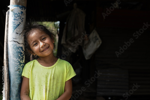 niña indigena sonriendo mientras mira la cámara photo