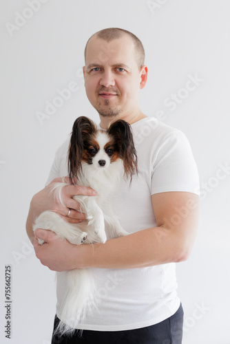 Man holding cute little papillon dog