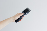 Woman's hand holding electric hair cut machine on white