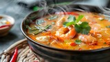Steaming bowl of Tom Yum Goong vibrant colors