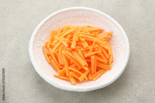 Fresh organic slice carrots on white plate grey background.
 photo