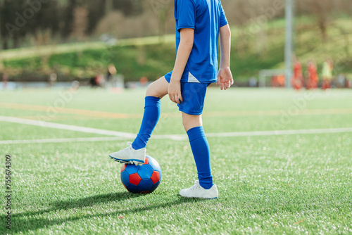 Young soccer player ready to kick the ball on field